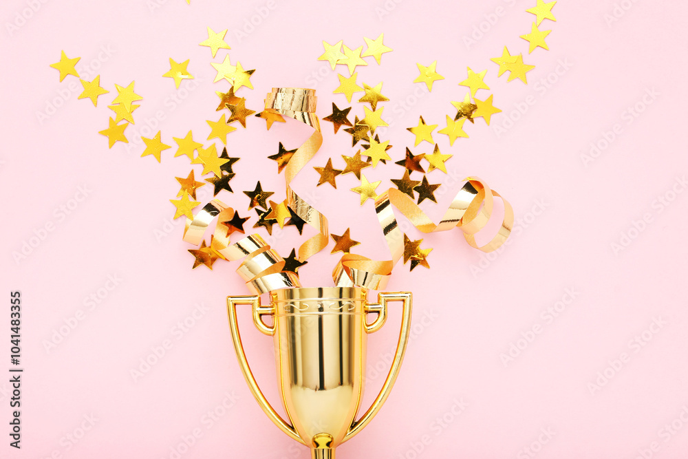 Golden trophy cup with confetti on pink background