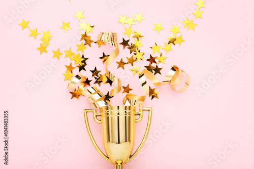 Obraz na płótnie Golden trophy cup with confetti on pink background w salonie