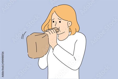 Hyperventilation syndrome in woman breathing into paper bag while trying to stop panic attack