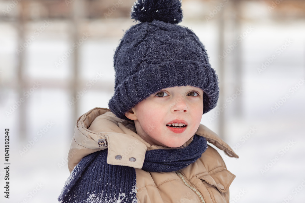 Portrait of cute little boy in beige winter clothes walks in winter park during a snowfall. Baby having fun. Cute child in a warm hat and scarf soiled in the snow. Outdoors winter activities for kids. Portrait of cute little boy in beige winter clothes walks in winter park during a snowfall. Baby having fun. Cute child in a warm hat and scarf soiled in the snow. Outdoors winter activities for kids.