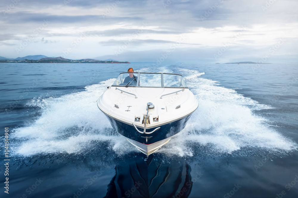 Close-up front view of a motorboat cruising with high speed over calm ocean