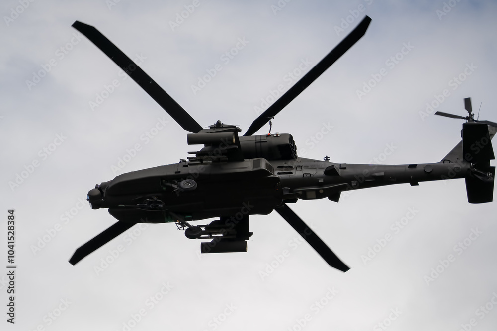 Fototapeta premium close-up of a British army Boeing Apache Attack helicopter gunship AH64E AH-64E ArmyAirCorp banking hard in low level overhead flight