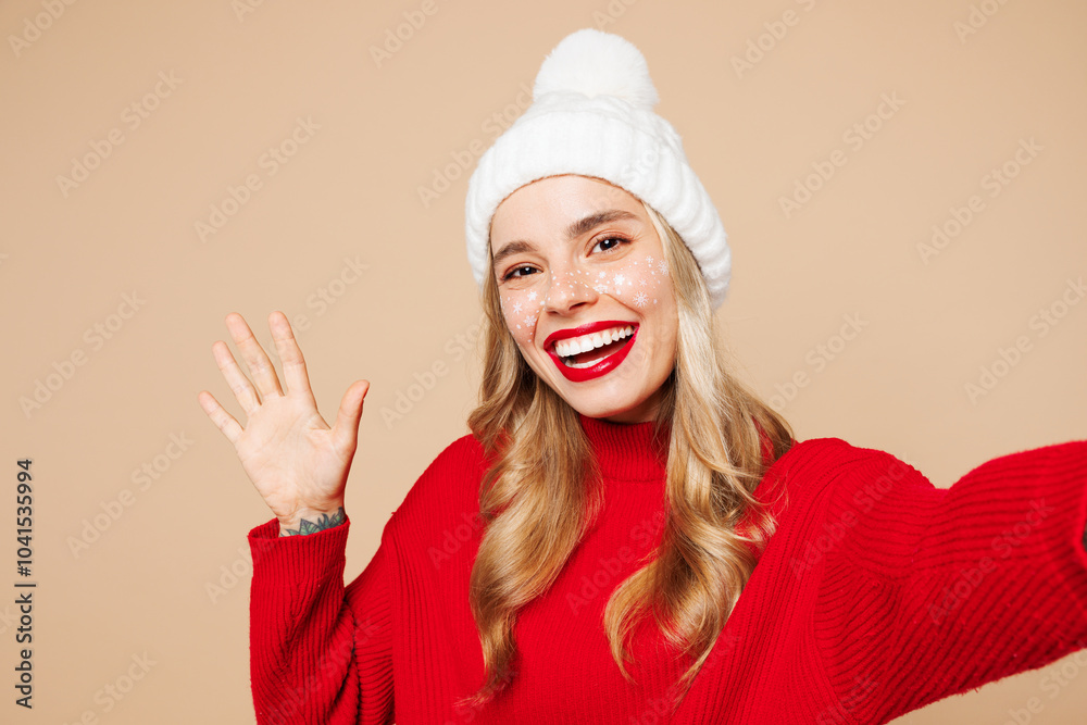 Close up merry fun young woman wear red sweater hat posing do selfie shot pov on mobile cell phone waving hand isolated on plain beige background. Happy New Year celebration Christmas holiday concept. Close up merry fun young woman wear red sweater hat posing do selfie shot pov on mobile cell phone waving hand isolated on plain beige background. Happy New Year celebration Christmas holiday concept.
