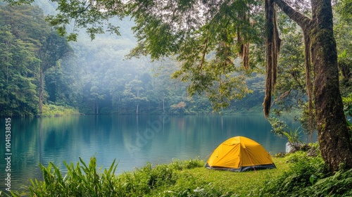 A tranquil lakeside scene showcases a bright yellow tent nestled among lush greenery ideal for camping lovers