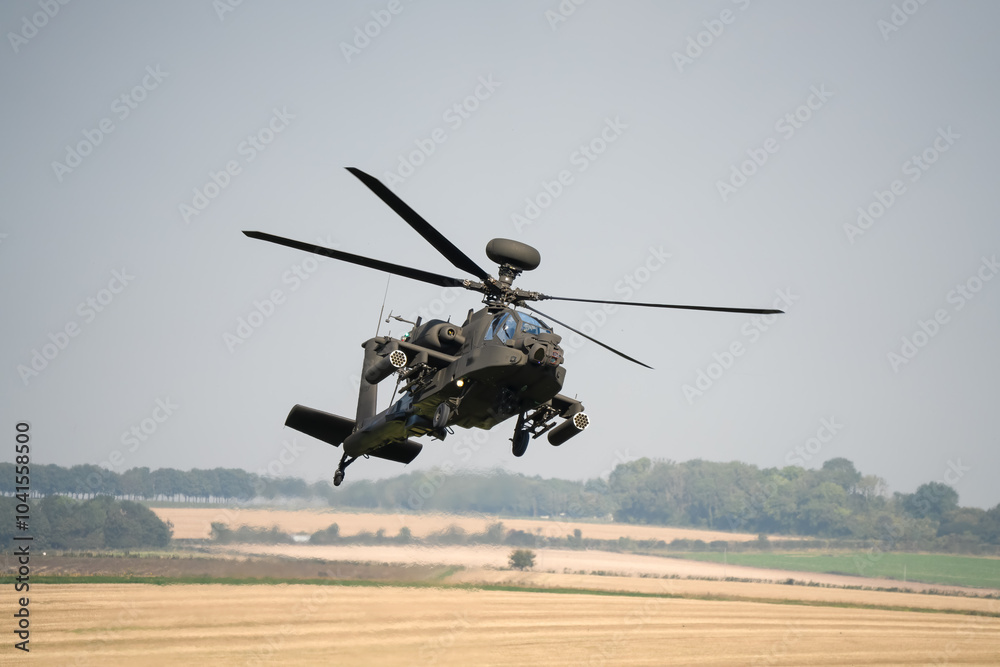 close-up front view of a British army Boeing Apache Attack helicopter gunship AH64E AH-64E ArmyAirCorp in low level banking flight close-up front view of a British army Boeing Apache Attack helicopter gunship AH64E AH-64E ArmyAirCorp in low level banking flight