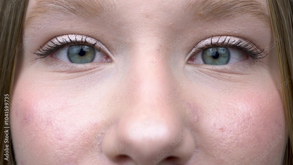 Naklejka premium Close-up of a girl opening and closing her blue eyes.