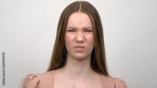 The girl is acting angry, showing her fists on a white background. photo