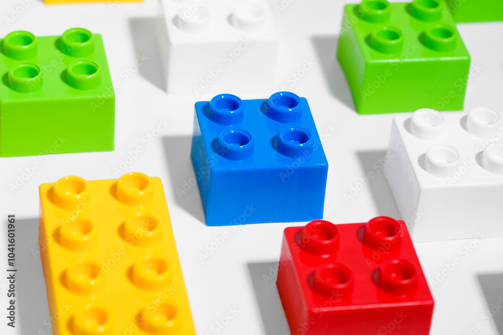 Naklejka premium Close up of many plastic colored pattern rainbow toy brick blocks for building constructions on white isolated background. The concept of children’s educational games. Image for your design