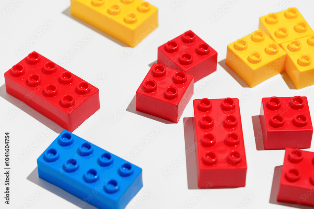 Angled view of many plastic colored building toy brick blocks on white isolated background. The concept of educational children’s games Angled view of many plastic colored building toy brick blocks on white isolated background. The concept of educational children’s games