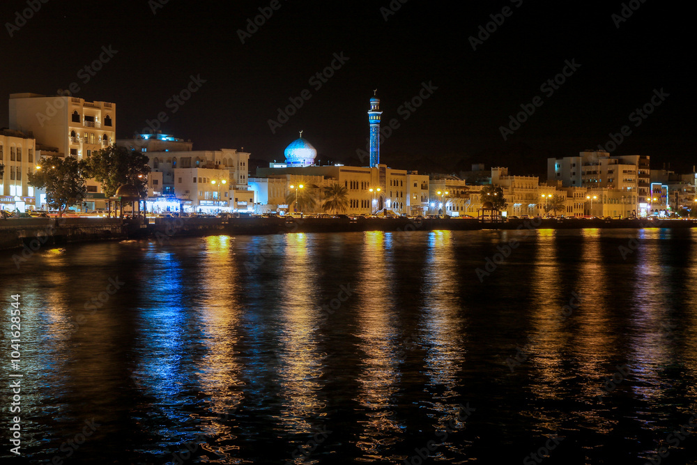 City of Muscat by night with lights reflecting on the water and the minaret illuminated in the skyline City of Muscat by night with lights reflecting on the water and the minaret illuminated in the skyline