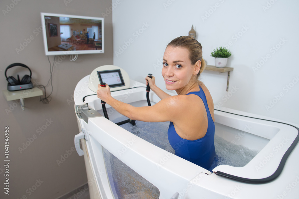 portrait of woman using fitness machine in water