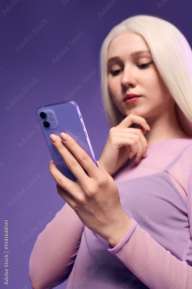 A fashionably dressed woman holds a phone in her hands while sending a message
A fashionably dressed woman holds a phone in her hands while sending a message