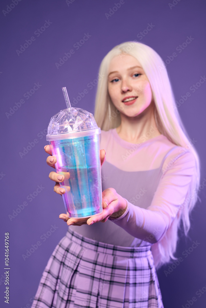 A lovely woman with white hair in stylish clothes holds a glass with a drinking tube in her hands A lovely woman with white hair in stylish clothes holds a glass with a drinking tube in her hands