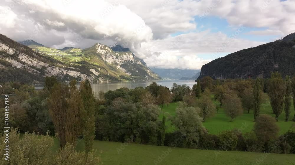 Drone revealing the magnitude and beauty of Lake Walensee, surrounded by stunning green landscapes and mountains in the Canton of St. Gallen, Switzerland. Drone revealing the magnitude and beauty of Lake Walensee, surrounded by stunning green landscapes and mountains in the Canton of St. Gallen, Switzerland.