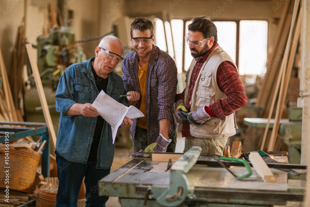 Carpenters working together on a project in their woodworking workshop Carpenters working together on a project in their woodworking workshop