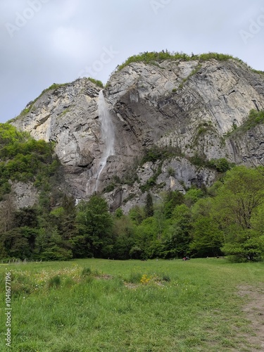 Arpenaz waterfall, one of France highest cascade in Haute Savoie in springtime with impressif cliff of Giffre Massif mountain, alpine landscape photo