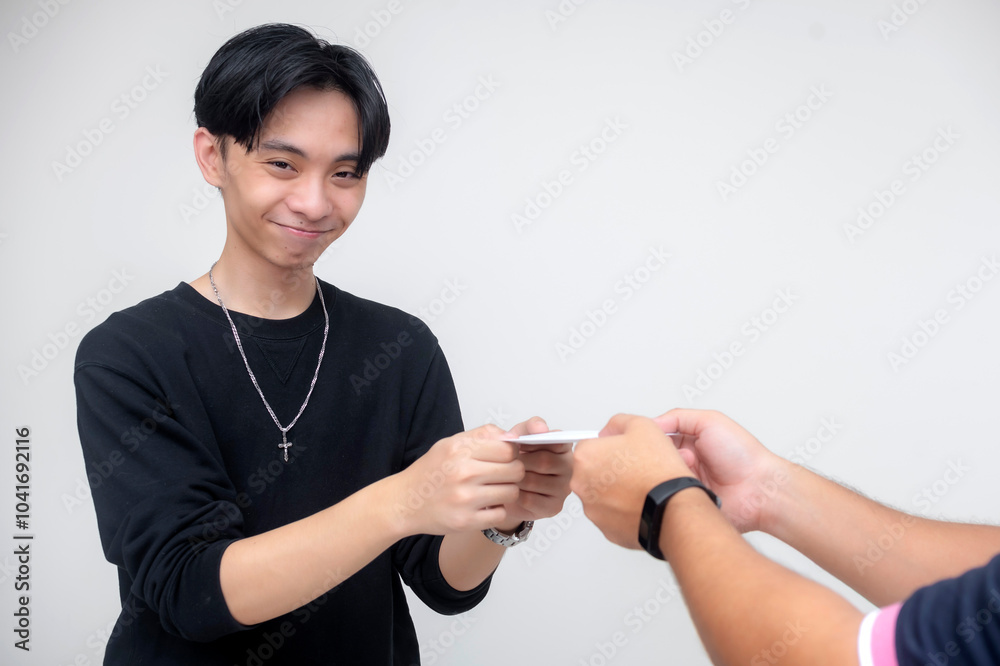 A young asian man smiling, grateful after accepting a small amount of cash enclosed in a white background. Isolated on a white background. A young asian man smiling, grateful after accepting a small amount of cash enclosed in a white background. Isolated on a white background.