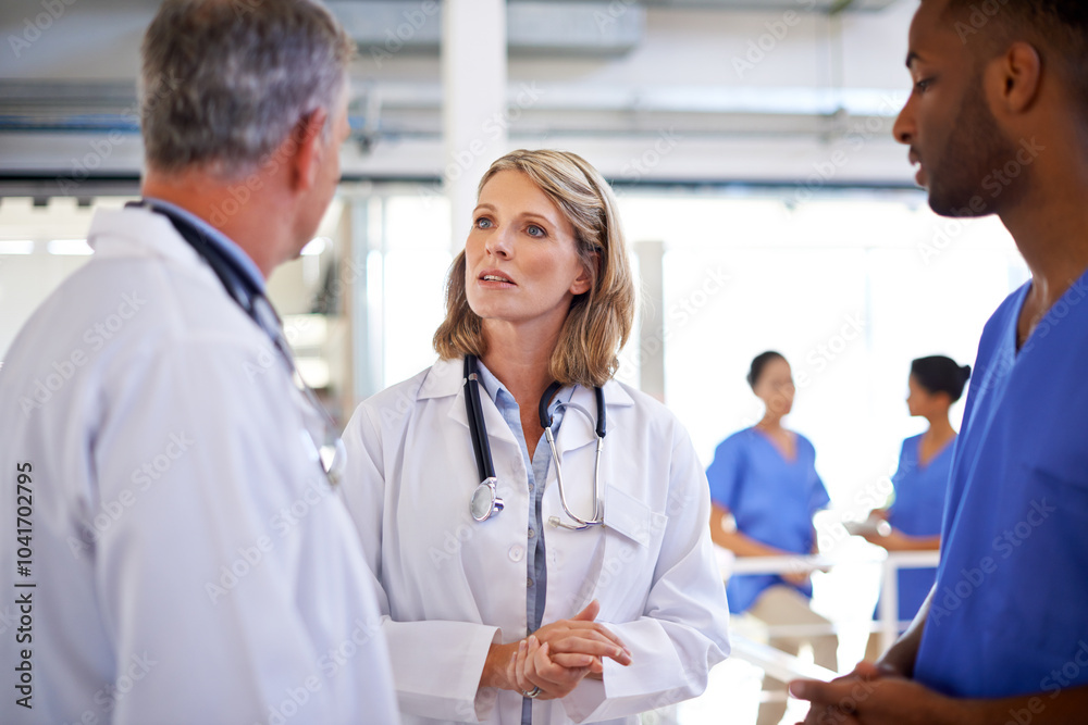 Hospital, meeting and doctors in discussion for teamwork on medical decision, diagnosis and treatment plan. Healthcare, clinic staff and men and women for consulting, advice and talking in hallway Hospital, meeting and doctors in discussion for teamwork on medical decision, diagnosis and treatment plan. Healthcare, clinic staff and men and women for consulting, advice and talking in hallway