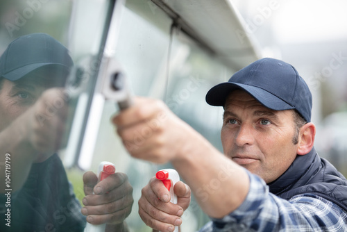 professional cleaning window with squeegee and spray photo