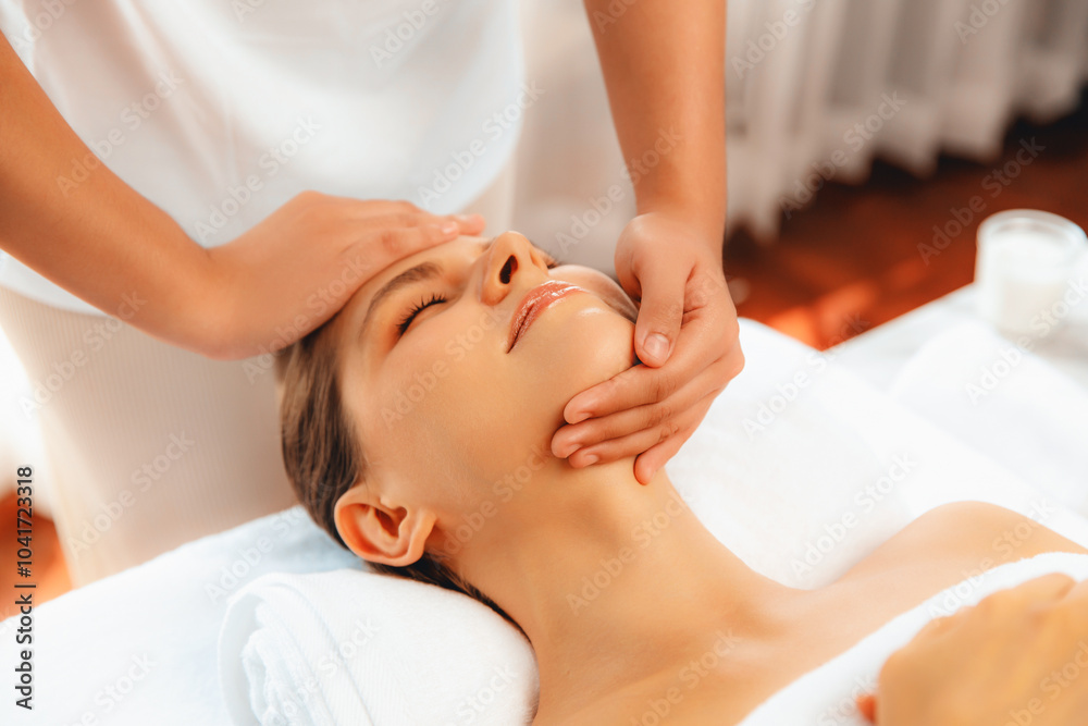 Caucasian woman enjoying relaxing anti-stress head massage and pampering facial beauty skin recreation leisure in dayspa modern light ambient at luxury resort or hotel spa salon. Quiescent Caucasian woman enjoying relaxing anti-stress head massage and pampering facial beauty skin recreation leisure in dayspa modern light ambient at luxury resort or hotel spa salon. Quiescent