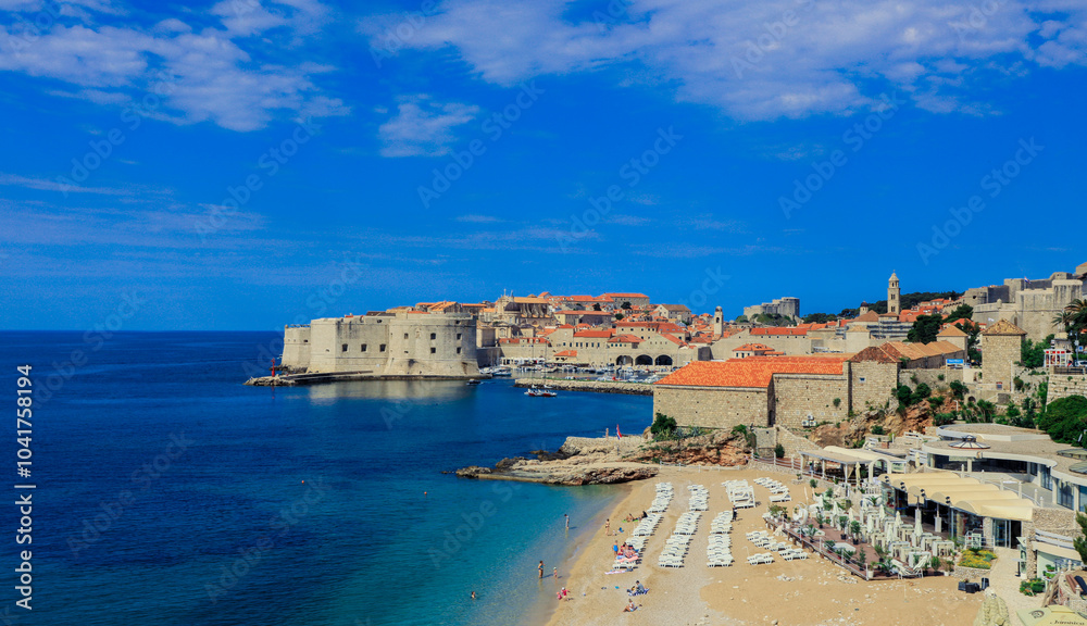 Fototapeta premium Stunning view of Dubrovnik coastline featuring historic architecture and clear blue skies during a sunny day