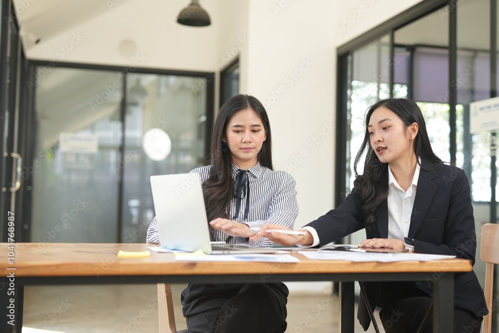 Two professional business executives working on laptop computer sitting at office desk, happy colleagues discussing company digital strategy. Two professional business executives working on laptop computer sitting at office desk, happy colleagues discussing company digital strategy.