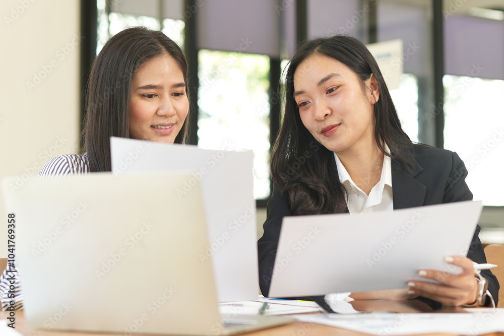 Happy Asian business people working together using laptop and tablet in office. Happy Asian business people working together using laptop and tablet in office.