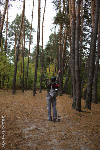 tourism. a tourist with a gray-burgundy backpack, mugs, a lantern with a compass travels through the wild forest