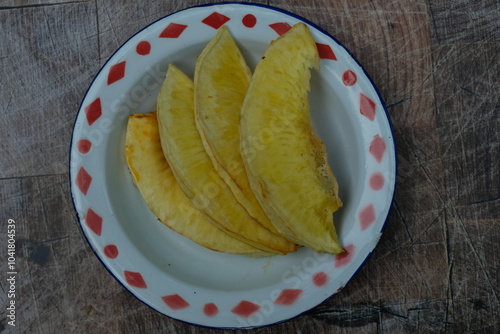 Fried breadfruit on an old zinc plate. photo