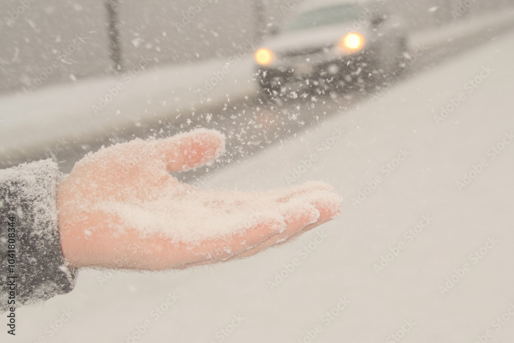 Fototapeta premium A hand is holding a snowflake in the snow