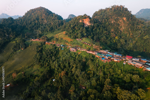 Aerial view of Morning fog and mountains with a rural village and sunrise from above