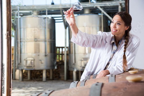 Professional woman checks the wine at factory