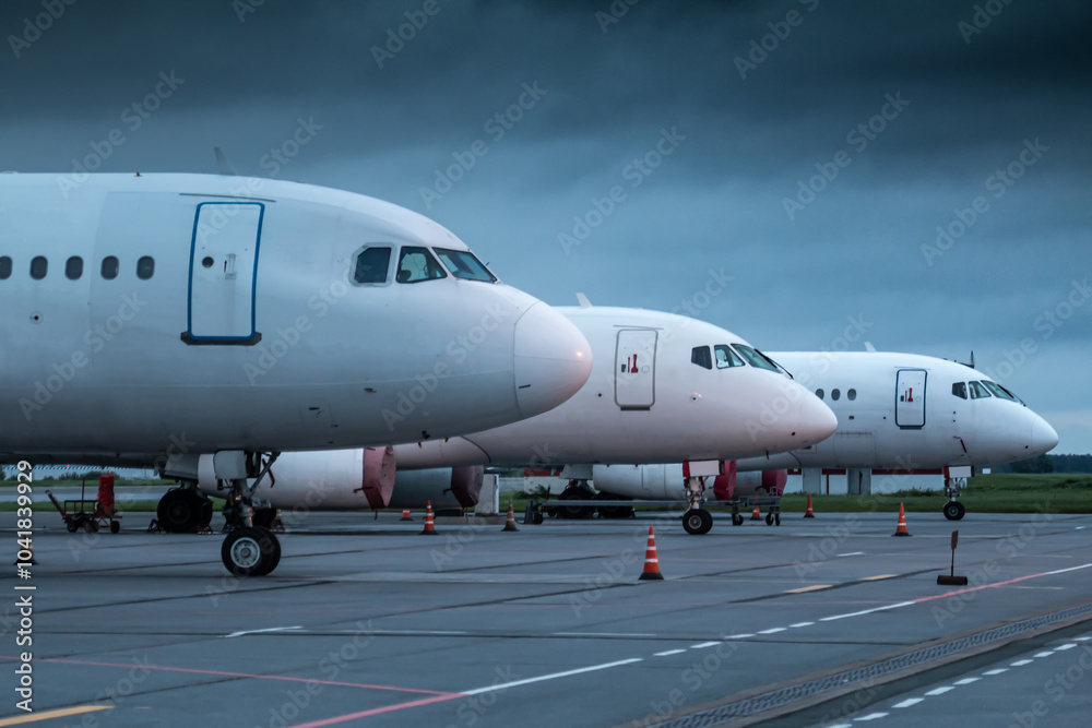 The noses of white passenger planes at the airport on an early cloudy morning The noses of white passenger planes at the airport on an early cloudy morning