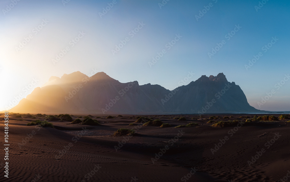 Stunning panoramic view of Vestrahorn, an impressive 454 metres tall mountain. It faces out to the sea on its southern side and is surrounded by a black sandy coastline. Iceland.