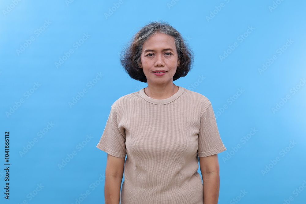 Portrait of attractive cheerful glad grey-haired senior woman standing smiling isolated over bright blue color background Portrait of attractive cheerful glad grey-haired senior woman standing smiling isolated over bright blue color background