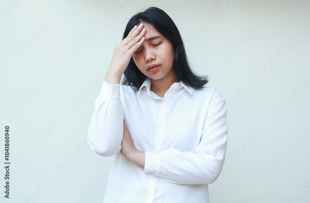 portrait of stressed asian young business woman folded arms and touching her forehead with closed eye tired of overtime work wearing white formal shirt, standing portrait of stressed asian young business woman folded arms and touching her forehead with closed eye tired of overtime work wearing white formal shirt, standing