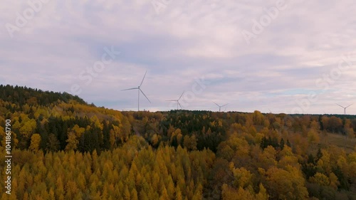 4K Video - Windmills rotating in the horizon over a fall forest in Sweden