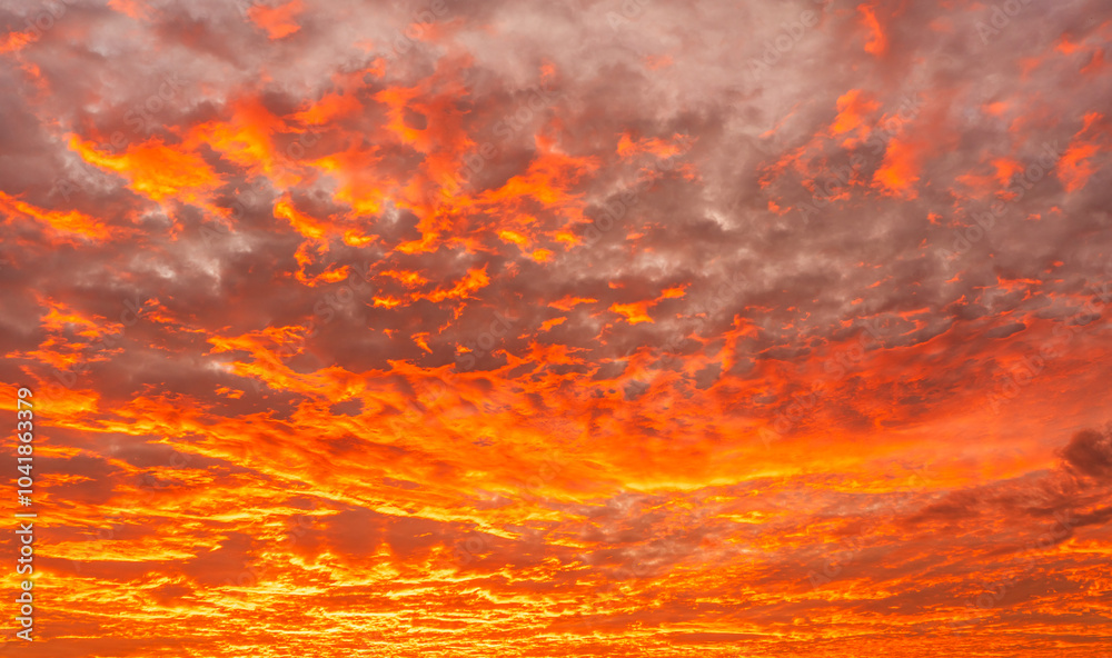 Fototapeta premium Dramatic red sky, Sunset fire sky with orange, yellow colorful sunlight reflected fluffy clouds in the evening after sun down, Dusk sky background 