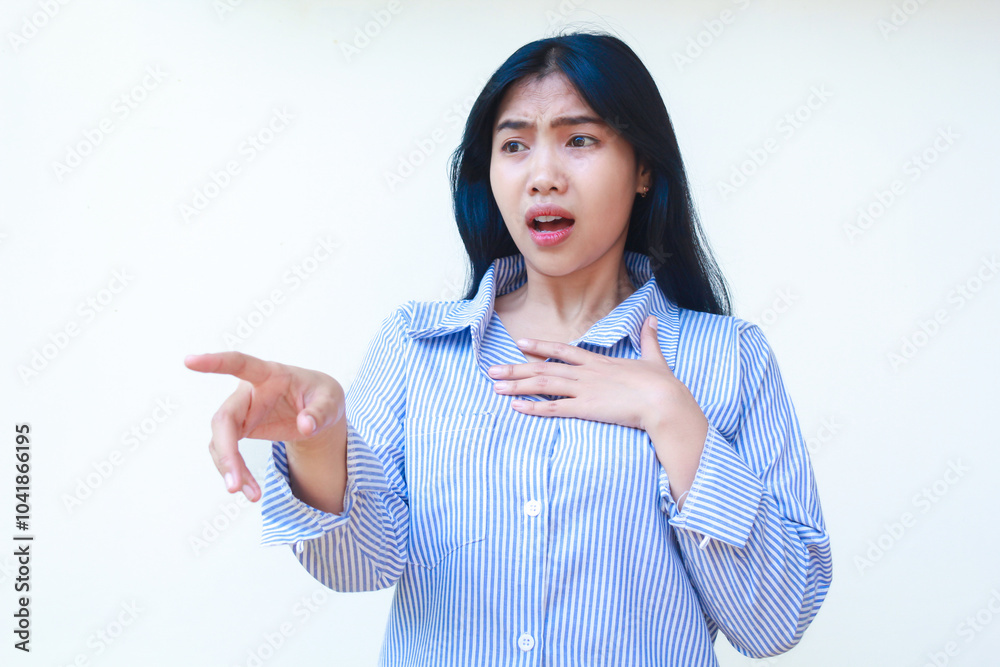 shocked asian woman pointing to empty space and touching chest wearing striped shirt isolated on white background shocked asian woman pointing to empty space and touching chest wearing striped shirt isolated on white background
