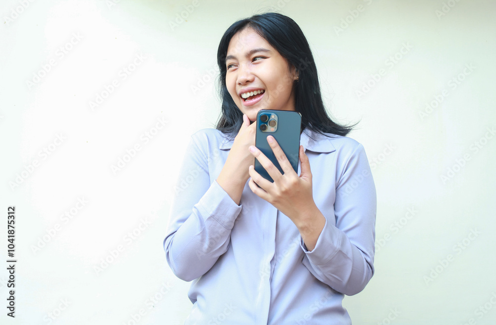 playful asian young business woman looking away while holding cell phone with hand on chin, read good new on social media and watching funny videos, wearing formal shirt isolated on white background playful asian young business woman looking away while holding cell phone with hand on chin, read good new on social media and watching funny videos, wearing formal shirt isolated on white background