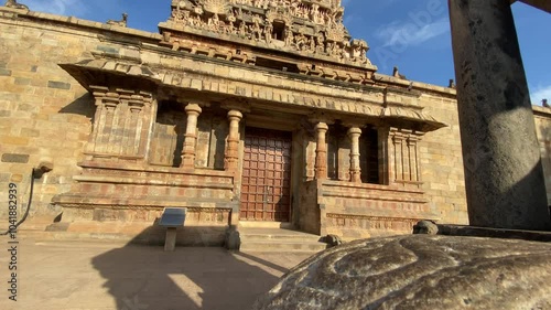Airavatesvara Temple, intricate stone sculptures adorn the entry, depicting gods and mythical scenes. The temple’s stone exteriors blend with the serene surroundings, creating a timeless, peaceful .