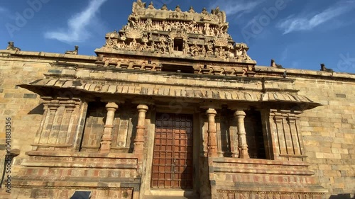 Airavatesvara Temple, intricate stone sculptures adorn the entry, depicting gods and mythical scenes. The temple’s stone exteriors blend with the serene surroundings, creating a timeless, peaceful .