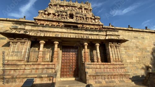 Airavatesvara Temple, intricate stone sculptures adorn the entry, depicting gods and mythical scenes. The temple’s stone exteriors blend with the serene surroundings, creating a timeless, peaceful .