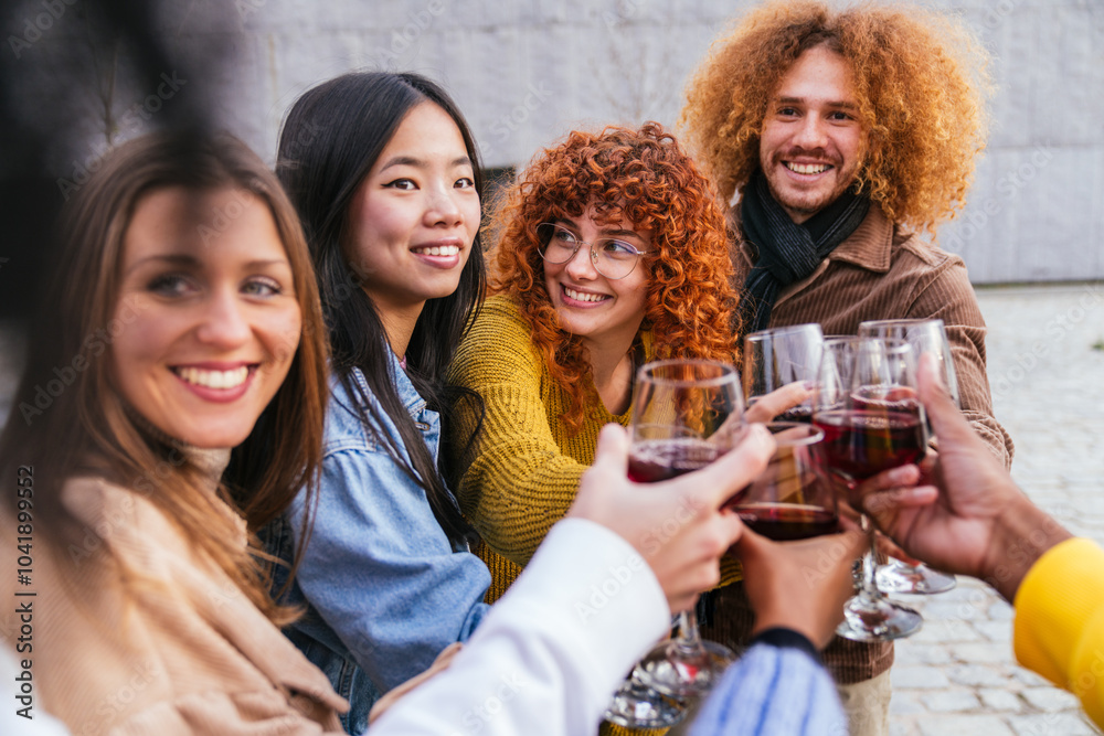 Group of multiethnic friends making a toast drinking wine together Group of multiethnic friends making a toast drinking wine together