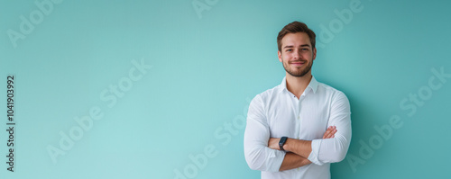 Handsome smiling man in white shirt on pastel light blue background, wide copyspace banner
