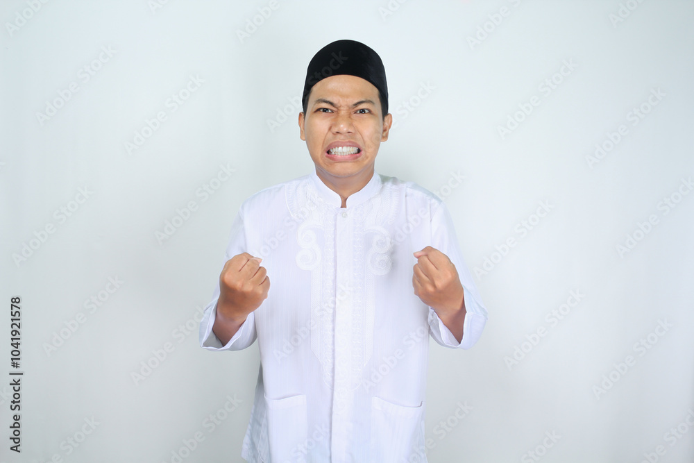 annoyed muslim asian man isolated on white background raising fist with angry face annoyed muslim asian man isolated on white background raising fist with angry face