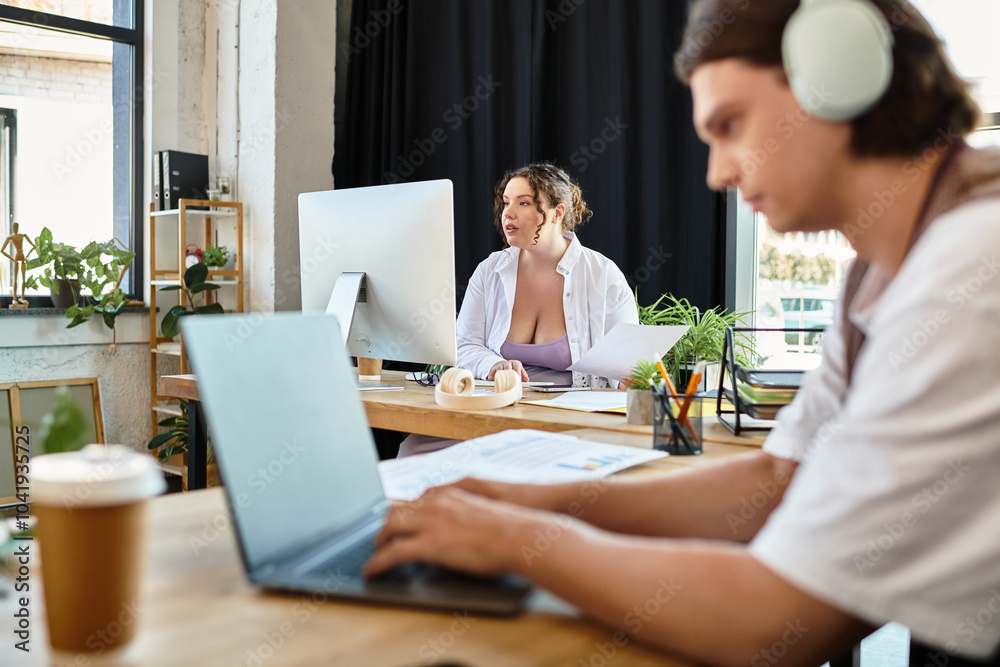 A young plus size woman engages in a collaborative task with her male friend in a cozy workspace. A young plus size woman engages in a collaborative task with her male friend in a cozy workspace.