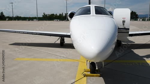 private jet cockpit sunlight shining aircraft parked airport both luxury aviation head on front panning shot view sunshine executive business travel airplane high-end  photo