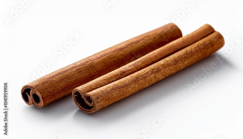 two brown vegeterian cinnamon sticks lying on white background