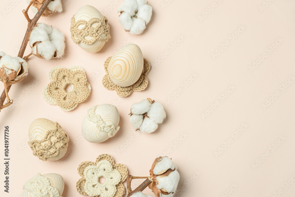 Craft eggs, knitted and cotton flowers on soft beige background. Top view. Copy space